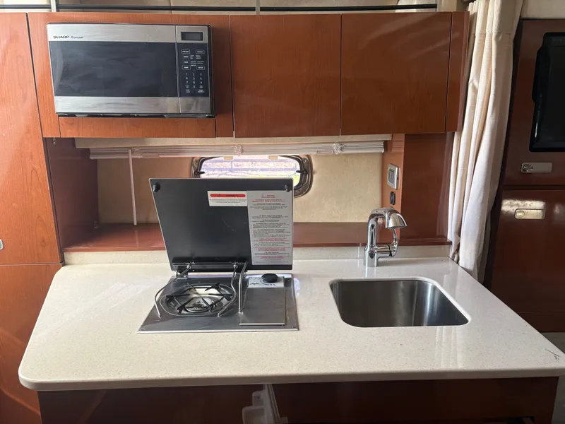 Slide: The Image of The galley of a 2010 Sea Ray Sundancer 310 with a microwave, stove, and sink. - 29