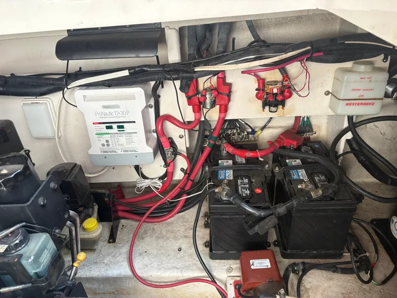 Slide: The Image of The engine compartment of a 2010 Sea Ray Sundancer 310 shows batteries and electrical wiring. - 50