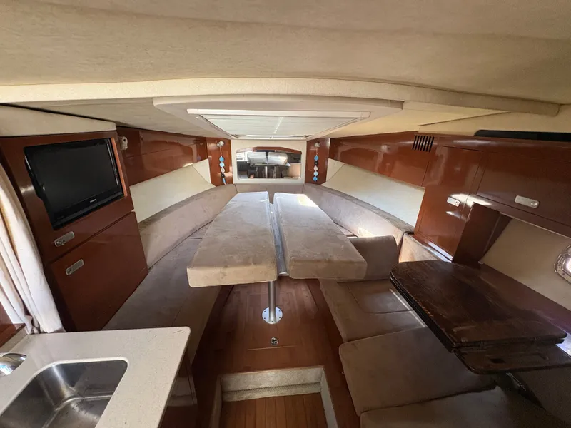 Slide: The Image of Interior of a 2010 Sea Ray Sundancer 310 with cozy seating area and wooden table. - 24