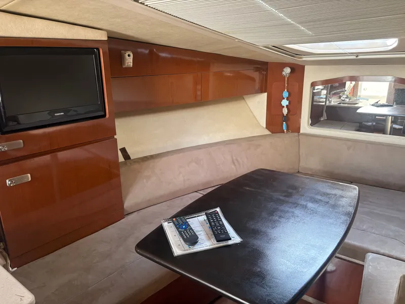 Slide: The Image of Interior of the 2010 Sea Ray Sundancer 310 with cozy seating area and television. - 18
