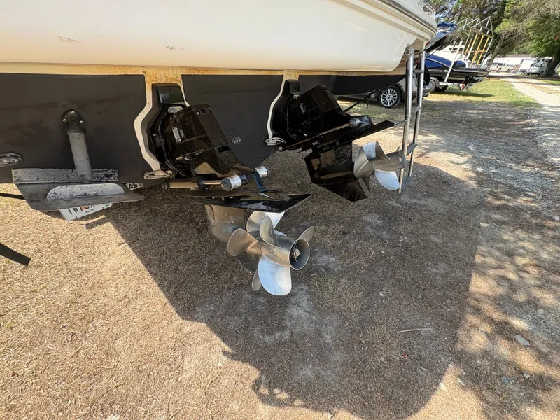 Slide: The Image of Rear view of a 2010 Sea Ray Sundancer 310 with dual propellers on dry ground. - 48