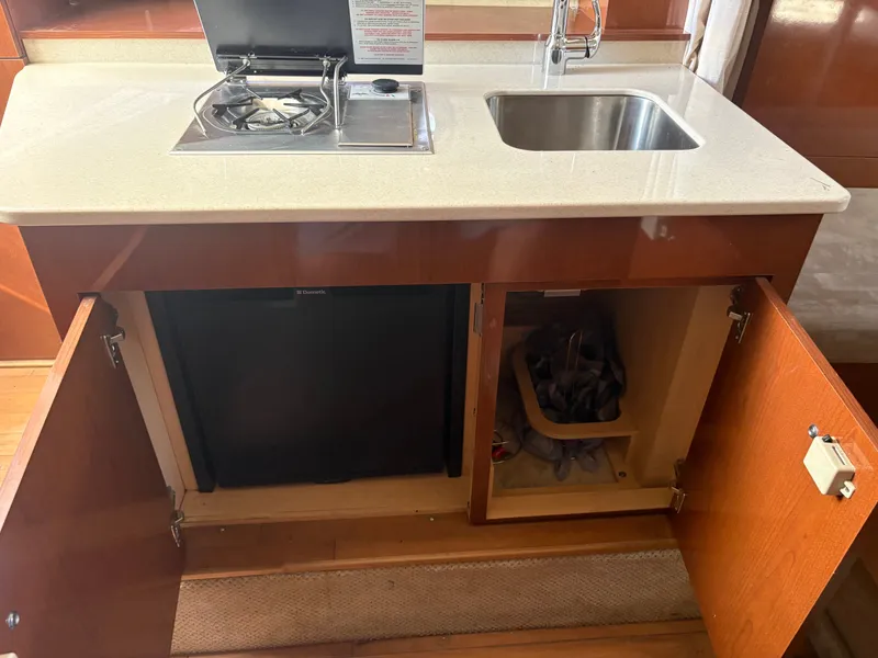 Slide: The Image of The galley of a 2010 Sea Ray Sundancer 310 with a sink, stove, and cabinets. - 31