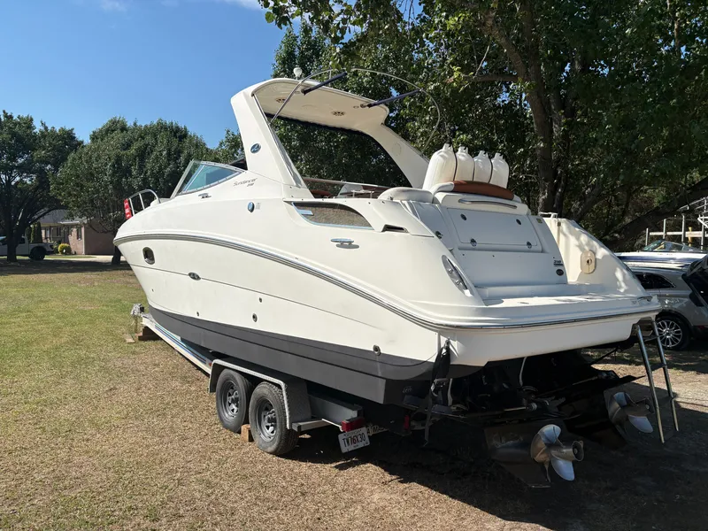 Slide: The Image of 2010 Sea Ray Sundancer 310 on a trailer, surrounded by trees. - 4