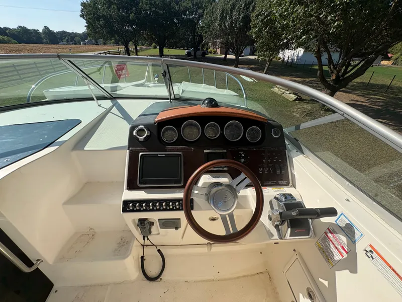 Slide: The Image of The image shows the helm of a 2010 Sea Ray Sundancer 310 with multiple instruments. - 11