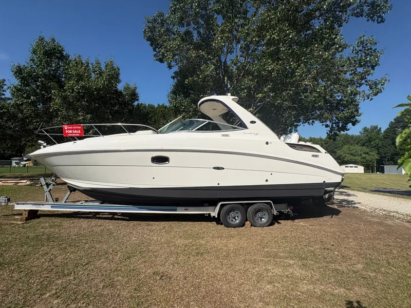 Slide: The Image of 2010 Sea Ray Sundancer 310 on a trailer, surrounded by trees, with a 'For Sale' sign. - 3