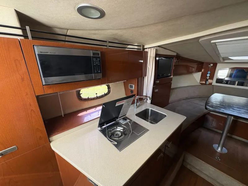 Slide: The Image of Interior of the Sea Ray Sundancer 310 with kitchenette, sink, and dining area. - 19