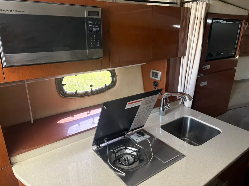 Slide: The Image of The galley of a 2010 Sea Ray Sundancer 310 with stove, sink, and microwave. - 28