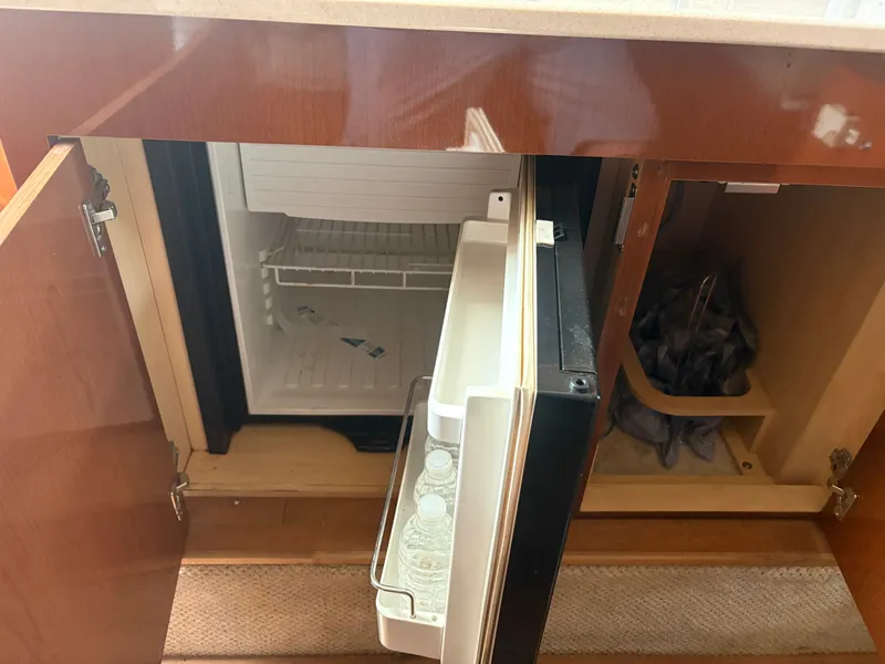 Slide: The Image of An open fridge in a boat cabin with water bottles inside. - 33