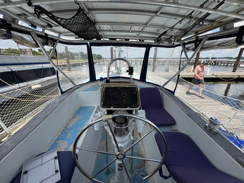 Slide: The Image of The cockpit of a 1980 Gulfstar 50 CC Ketch with a steering wheel and navigation system. - 16