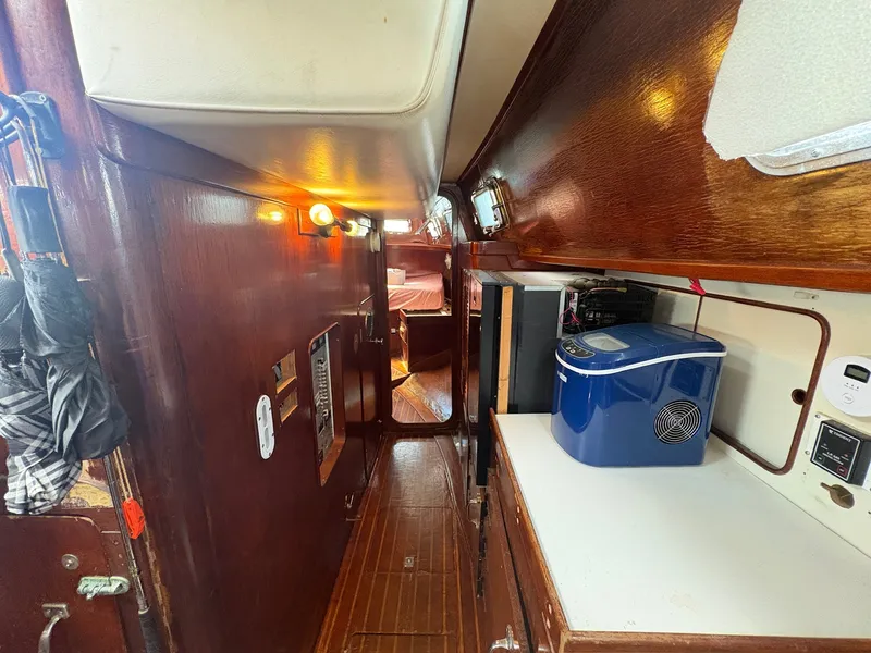 Slide: The Image of Interior of a 1980 Gulfstar 50 CC Ketch with wooden walls and a small kitchen area. - 27