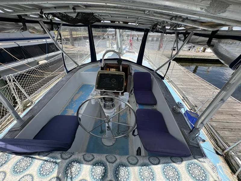 Slide: The Image of The cockpit of a 1980 Gulfstar 50 CC Ketch with a steering wheel and blue cushions. - 14