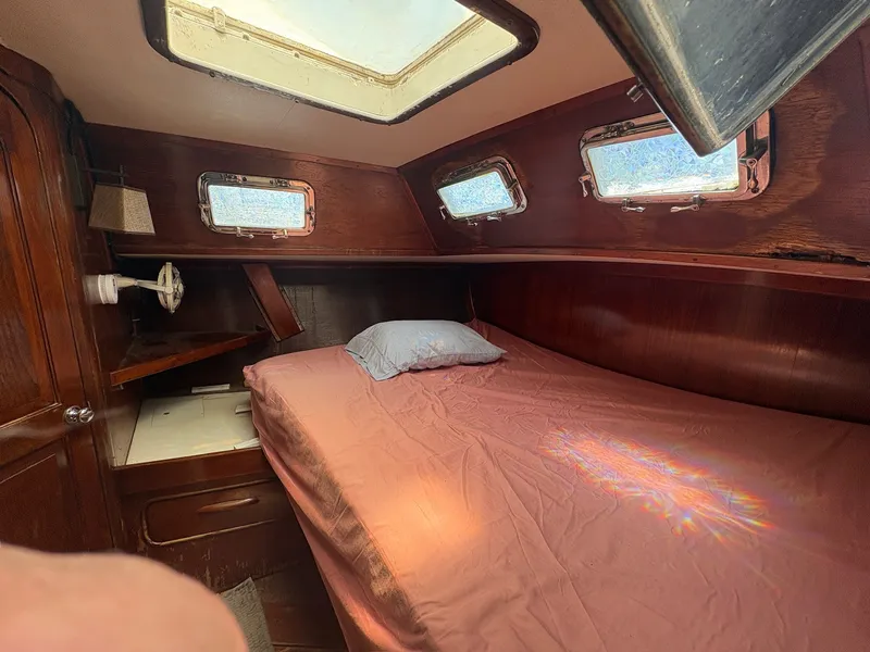 Slide: The Image of The cabin of a 1980 Gulfstar 50 CC Ketch with a bed and several windows. - 33