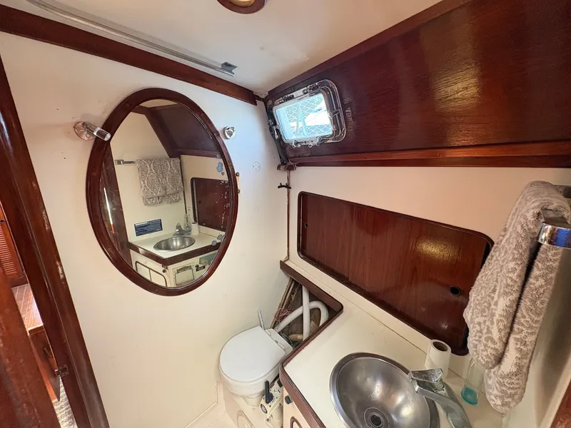 Slide: The Image of The image shows a boat bathroom with a round mirror, sink, and toilet. - 39