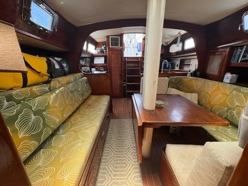 Slide: The Image of The interior of a 1980 Gulfstar 50 CC Ketch features cozy seating and wooden furnishings. - 18