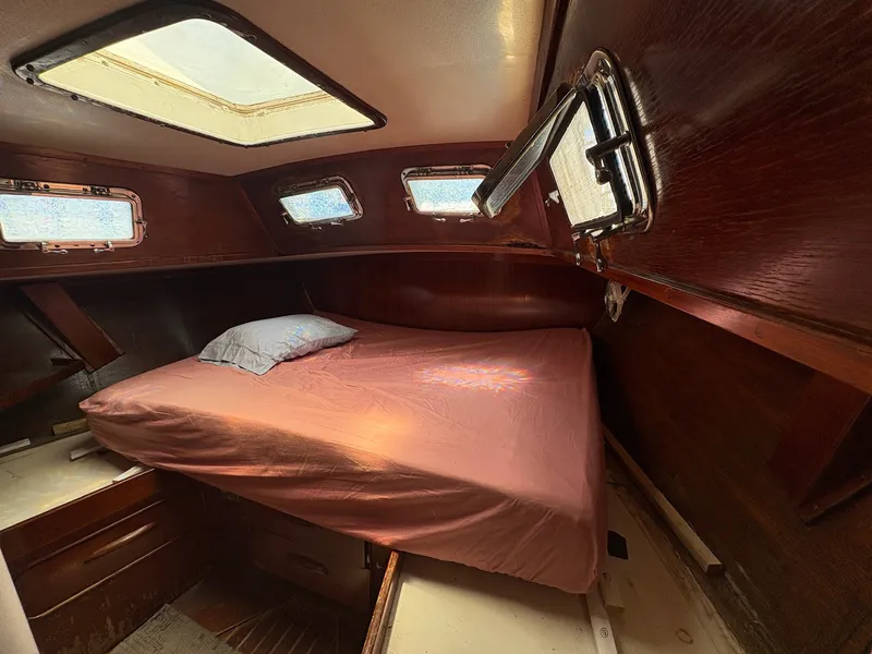 Slide: The Image of The cabin of a 1980 Gulfstar 50 CC Ketch with a bed and wood paneling. - 32