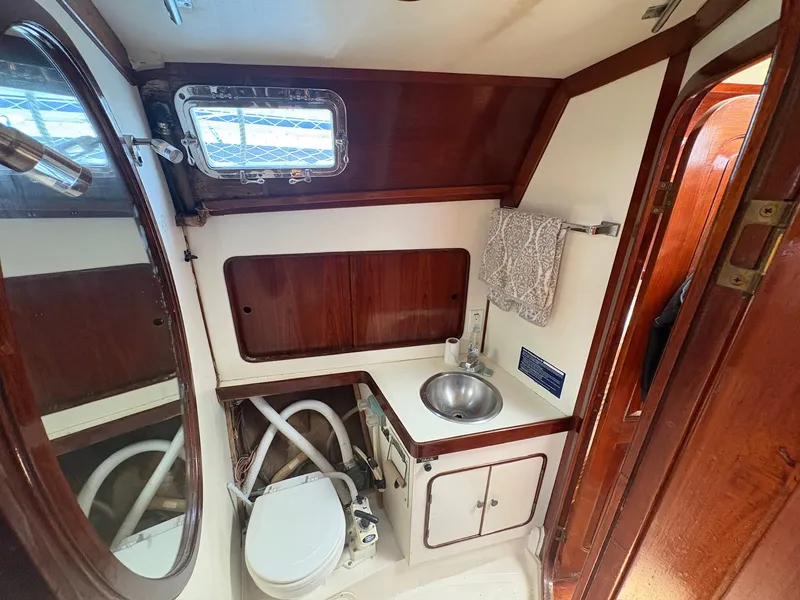 Slide: The Image of The image shows a boat bathroom with a sink, toilet, and wood paneling. - 45