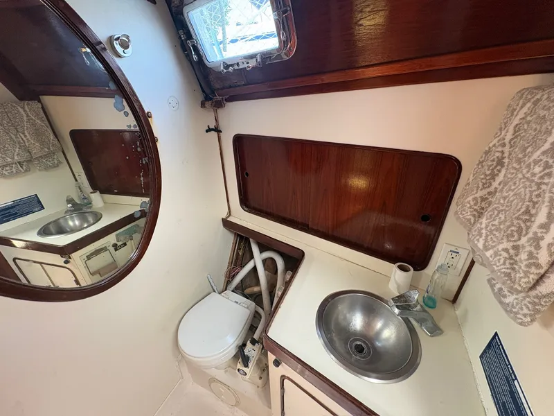 Slide: The Image of A boat bathroom with a sink, toilet, and mirror. - 38