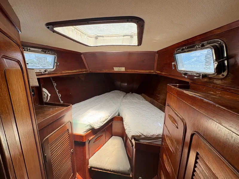 Slide: The Image of The cabin of a 1980 Gulfstar 50 CC Ketch with wood paneling and two beds. - 43