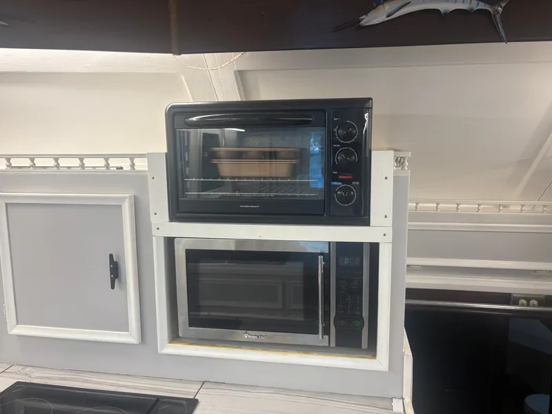 Slide: The Image of The galley of a 1973 Hatteras 53 Convertible with a microwave and oven. - 27