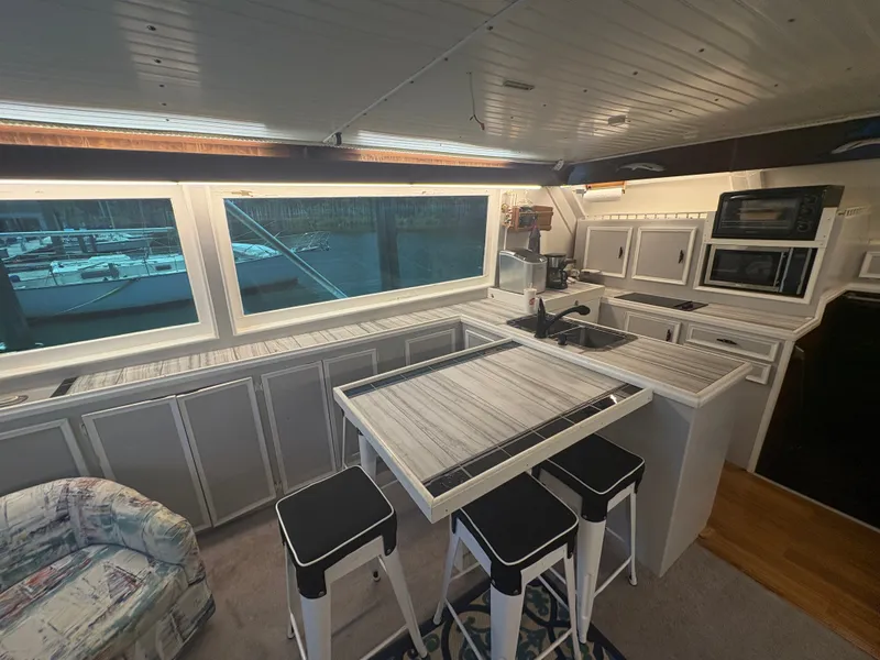 Slide: The Image of Interior of a 1973 Hatteras 53 Convertible with a modern kitchen and large windows. - 16