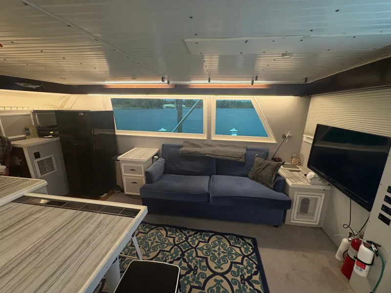Slide: The Image of Interior of a 1973 Hatteras 53 Convertible with a sofa, table, and large window. - 23