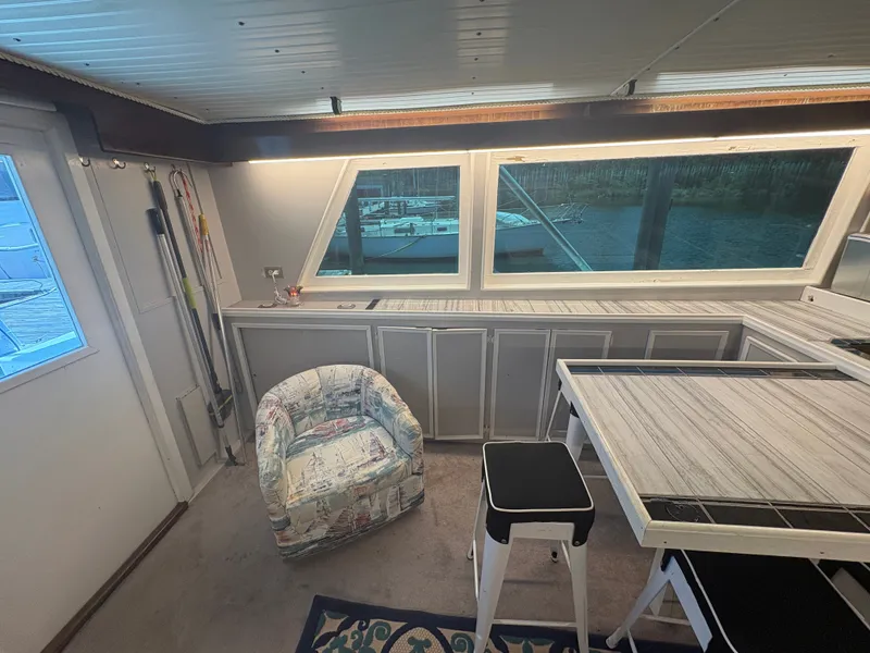 Slide: The Image of Interior of a 1973 Hatteras 53 Convertible with a table, stools, and an armchair. - 20