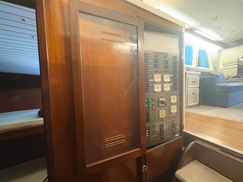 Slide: The Image of Electrical panel in a 1973 Hatteras 53 Convertible, featuring wood elements and a cozy interior. - 30