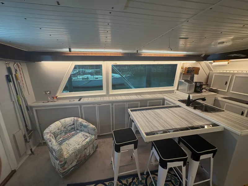 Slide: The Image of Interior of a 1973 Hatteras 53 Convertible with a modern kitchen and seating area. - 19