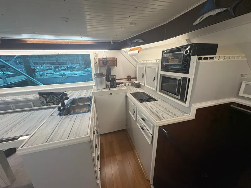 Slide: The Image of The galley of a 1973 Hatteras 53 Convertible with modern appliances and wooden flooring. - 25