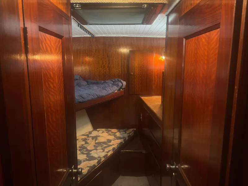 Slide: The Image of The 1973 Hatteras 53 Convertible cabin features a bunk bed and wood paneling. - 34