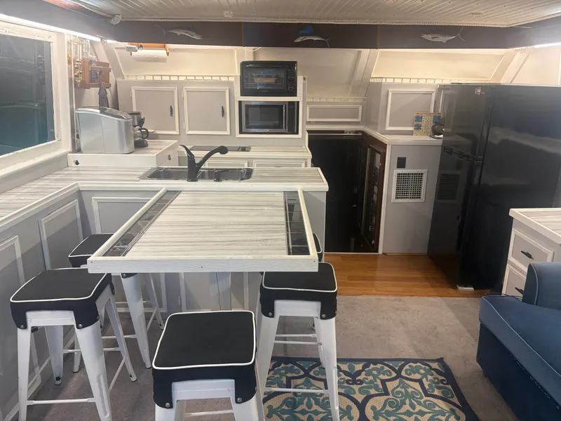 Slide: The Image of The kitchen of a 1973 Hatteras 53 Convertible with modern appliances and a breakfast bar. - 18
