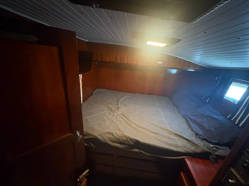 Slide: The Image of Cabin with a large bed, wooden walls, and a small window. - 49
