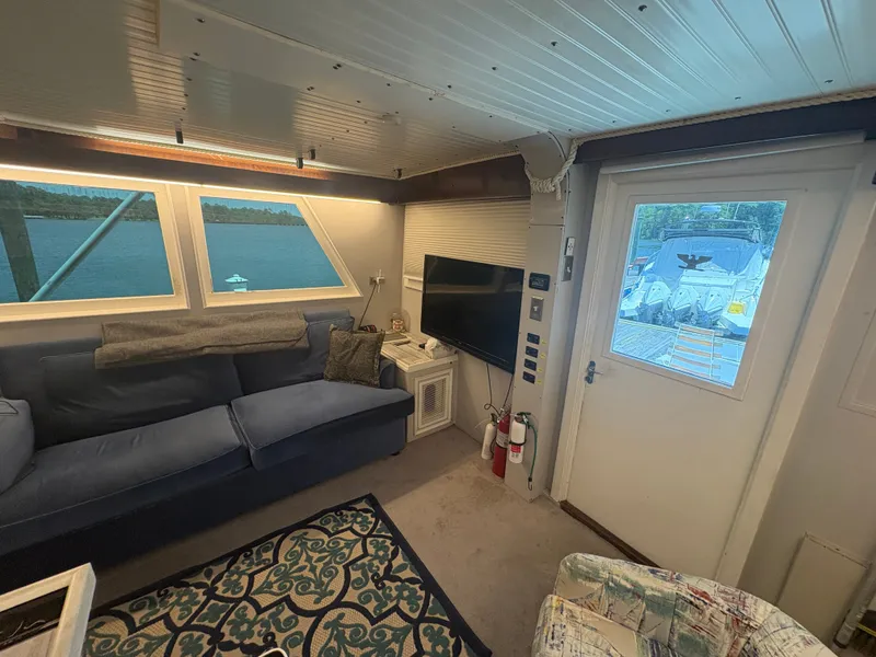 Slide: The Image of Interior of a 1973 Hatteras 53 Convertible with a sofa, rug, and television. - 24
