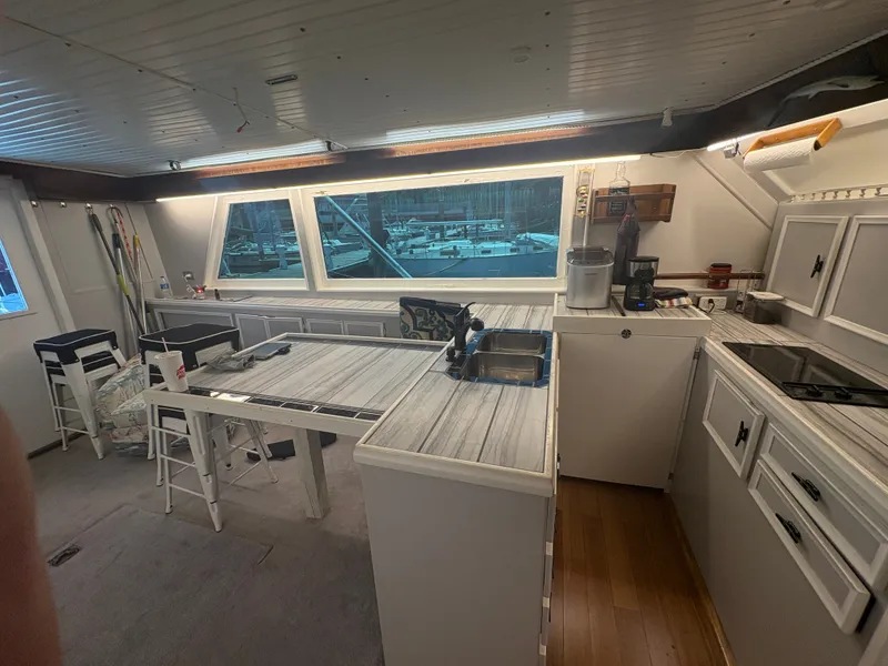 Slide: The Image of The kitchen of a 1973 Hatteras 53 Convertible with modern appliances and large windows. - 21