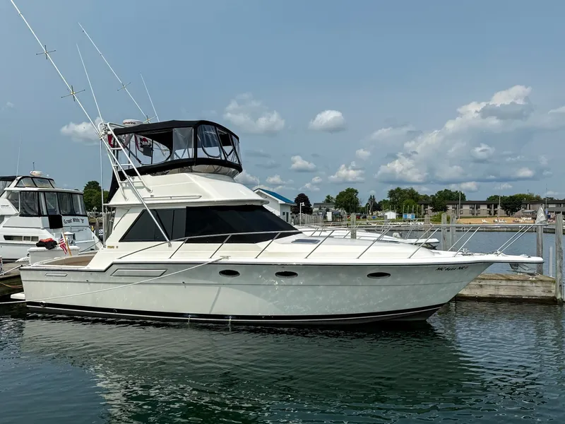 The Image of The 1989 Tiara Yachts 3600 Convertible is docked, featuring a flybridge and fishing rod holders. - 1