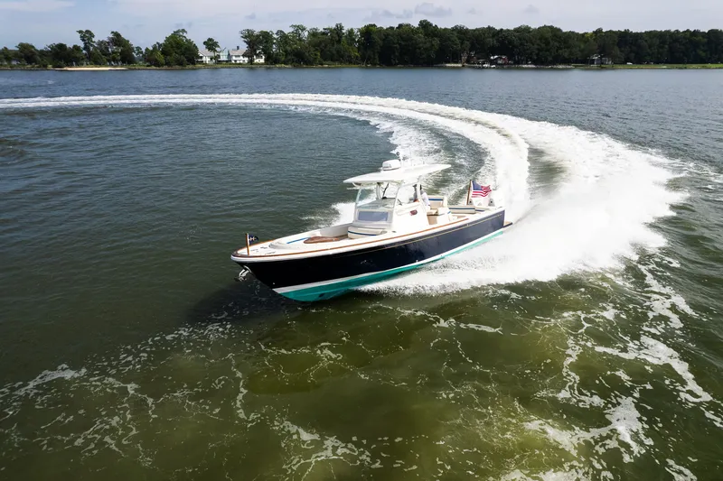 Slide: The Image of 2024 Hunt Yachts 32CC cruising on a lake, creating a dynamic water trail. - 9