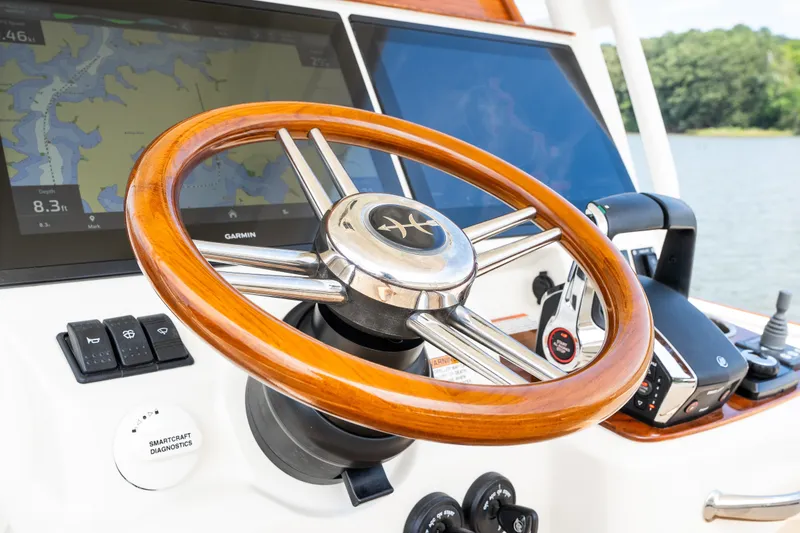 Slide: The Image of Steering wheel and controls of 2024 Hunt Yachts 32CC, featuring navigation screens. - 22