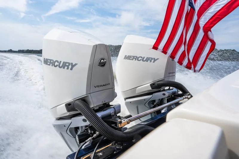 Slide: The Image of 2024 Hunt Yachts 32CC with dual Mercury Verado engines and American flag on open water. - 43