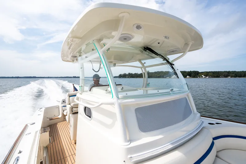 Slide: The Image of 2024 Hunt Yachts 32CC cruising on a serene lake under a clear sky. - 16