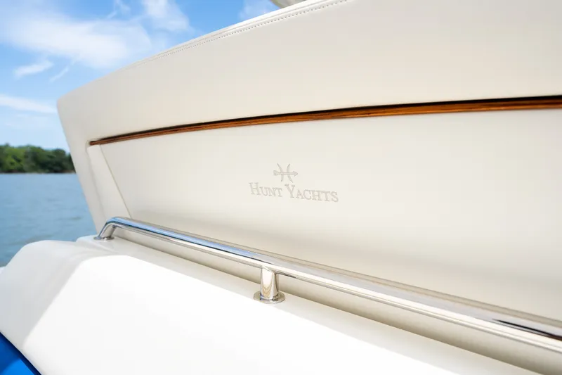 Slide: The Image of 2024 Hunt Yachts 32CC, elegant interior detail with logo, on a serene water backdrop. - 38