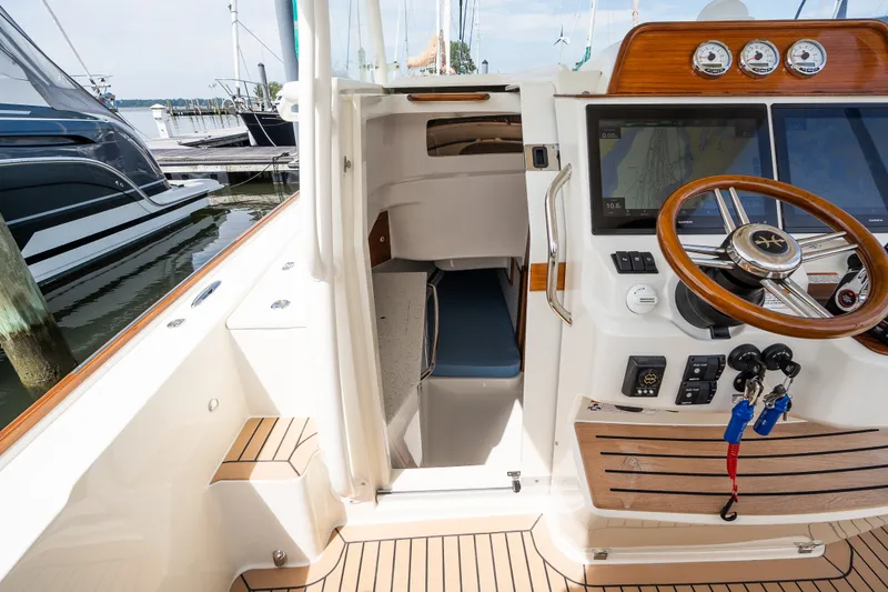 Slide: The Image of 2024 Hunt Yachts 32CC cockpit with helm, navigation screens, and cabin entrance. - 28