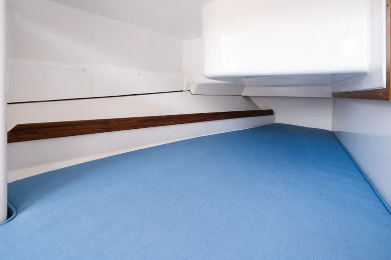 Slide: The Image of 2024 Hunt Yachts 32CC cabin interior with blue bedding and wooden accents. - 32