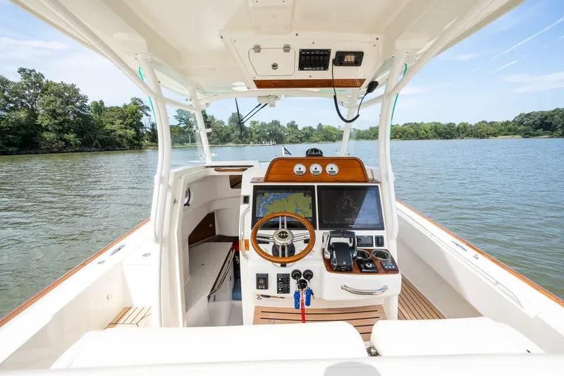 Slide: The Image of 2024 Hunt Yachts 32CC helm with advanced navigation, on a serene lake backdrop. - 20