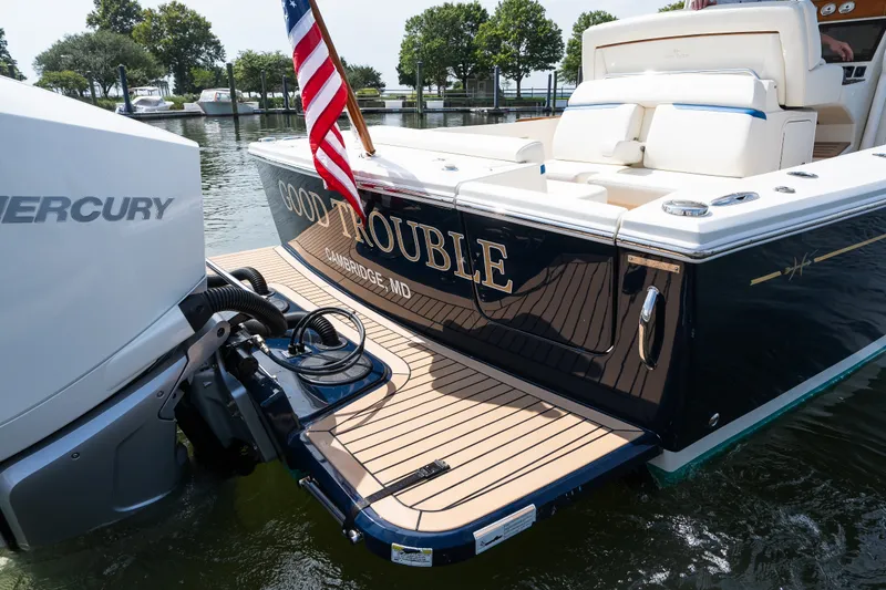 Slide: The Image of 2024 Hunt Yachts 32CC boat with Mercury engine, docked, displaying "Good Trouble" name. - 11