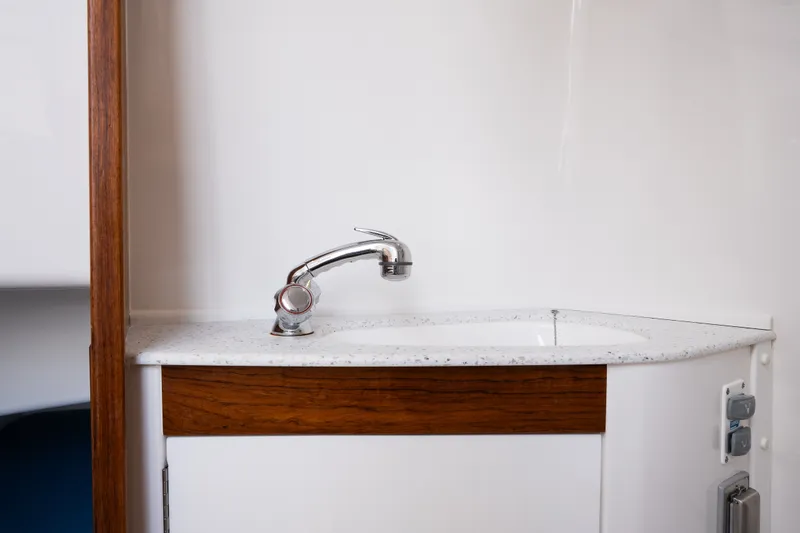 Slide: The Image of Modern sink area on 2024 Hunt Yachts 32CC, featuring sleek faucet and wood accents. - 34