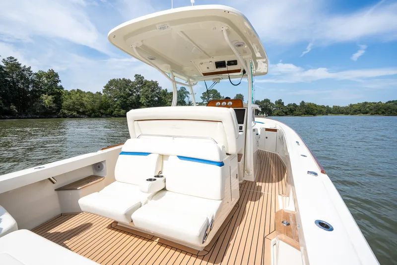 Slide: The Image of 2024 Hunt Yachts 32CC boat with sleek design on calm water, featuring comfortable seating. - 19