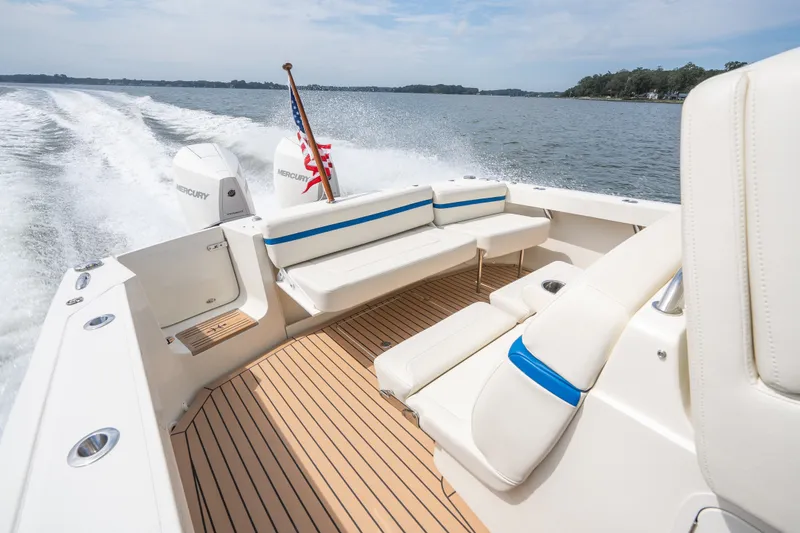 Slide: The Image of 2024 Hunt Yachts 32CC cruising on open water, featuring luxurious seating and powerful Mercury engines. - 13