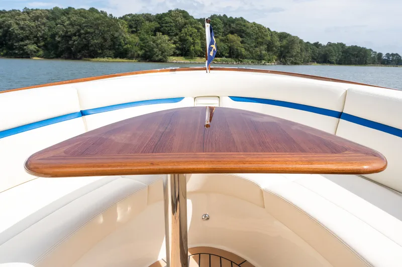 Slide: The Image of 2024 Hunt Yachts 32CC boat interior with elegant wooden table and scenic lake view. - 37