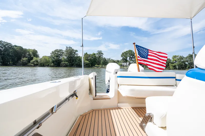 Slide: The Image of 2024 Hunt Yachts 32CC boat with American flag on calm water, sunny day. - 39