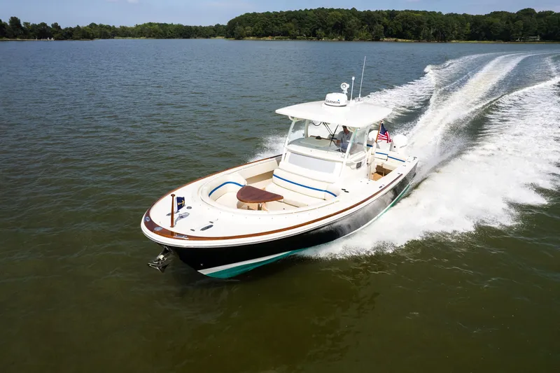 Slide: The Image of 2024 Hunt Yachts 32CC cruising on a serene lake, showcasing sleek design and performance. - 8